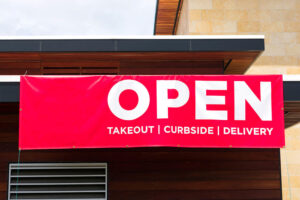A sign that says open for takeout, curbside and delivery.