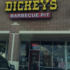 A large brick building with dickey 's barbecue pit on the front.