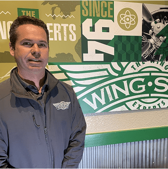 Man standing in front of Wingstop mural.