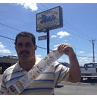 Man holding lottery tickets outside store.