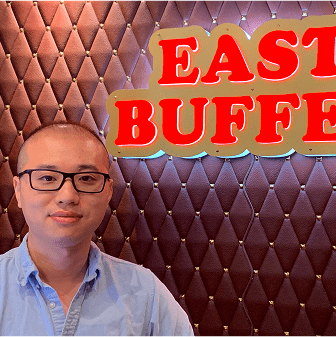 Man standing in front of "East Buffet" sign.