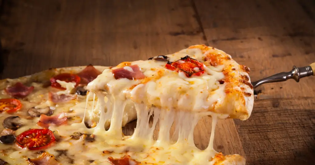  A slice of pizza with toppings and cheese.